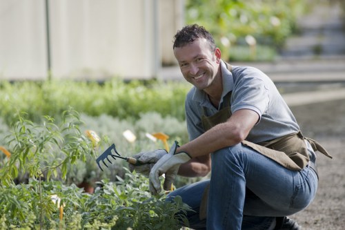 Crew members wearing protective gear and using powered garden equipment